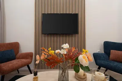 a vase of flowers on a table in a living room at LIV - Vintage Acropolis Apartment in Athens