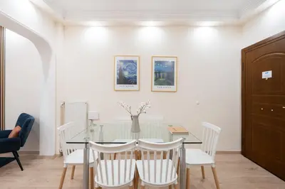 a dining room with a glass table and white chairs at LIV - Vintage Acropolis Apartment in Athens