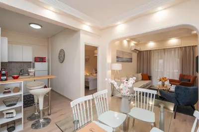 a living room and a kitchen with a dining room at LIV - Vintage Acropolis Apartment in Athens