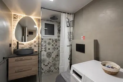 a bathroom with a shower with a sink and a mirror at LIV - Vintage Acropolis Apartment in Athens