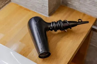 a black hair dryer sitting on a wooden table at SYNTAGMA VOULIS STREET MODERN APARTMENT in Athens