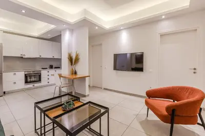 a living room with a glass table and a chair at SYNTAGMA VOULIS STREET MODERN APARTMENT in Athens