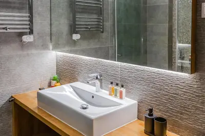 a bathroom with a white sink and a mirror at SYNTAGMA VOULIS STREET MODERN APARTMENT in Athens