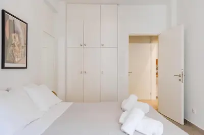 a white bedroom with a white bed and white cabinets at SYNTAGMA VOULIS STREET MODERN APARTMENT in Athens