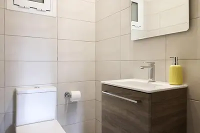 a white bathroom with a toilet and a sink at Comfort & Relax apartment in Athens Riviera in Athens
