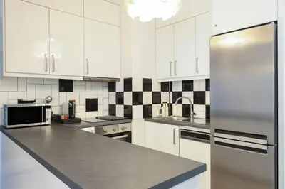a kitchen with white cabinets and a stainless steel refrigerator at Comfort & Relax apartment in Athens Riviera in Athens
