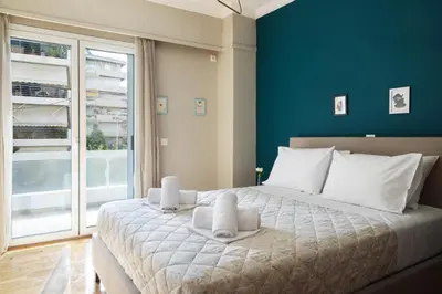 a bedroom with a large bed with a blue wall at Comfort & Relax apartment in Athens Riviera in Athens