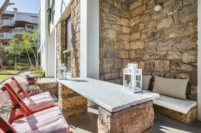a table and chairs on a patio with a stone wall at Glyfada 2 bedrooms 4 persons apartment by MPS in Athens