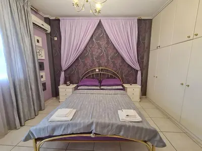a bedroom with a bed with purple sheets and purple curtains at Άνετο, μεγάλο σπίτι κοντά στο μετρό in Piraeus