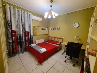a bedroom with a bed and a desk and a clock at Άνετο, μεγάλο σπίτι κοντά στο μετρό in Piraeus