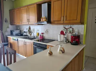 a kitchen with wooden cabinets and a white counter top at Άνετο, μεγάλο σπίτι κοντά στο μετρό in Piraeus