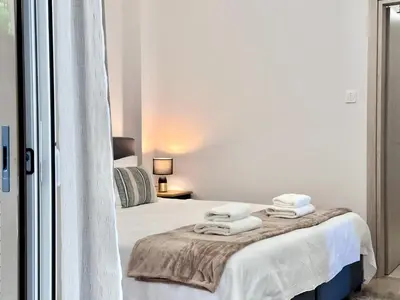 a white bedroom with a bed with towels on it at Elaia Luxury Selections Sapphire in Athens