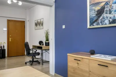 an office with a blue wall and a desk at Elaia Luxury Selections Sapphire in Athens