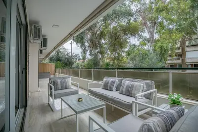 a patio with two chairs and a table on a balcony at Elaia Luxury Selections Sapphire in Athens