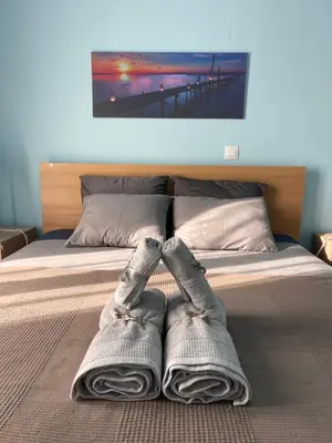 a bed with two pairs of socks on it at Seaside Escape Apartments - Apollon in Palaiá Fókaia