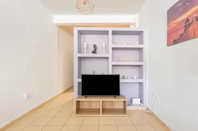 a living room with a tv on a shelf at Seaside Escape Apartments - Apollon in Palaiá Fókaia