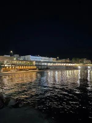 a city at night with lights on the water at Seaside Escape Apartments - Apollon in Palaiá Fókaia