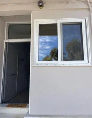a window on a house with a view of the sky at Seaside Escape Apartments - Apollon in Palaiá Fókaia