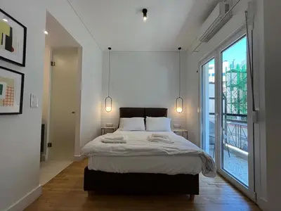 a bedroom with a large bed and a large window at Elegant Two Bedroom Apartment a few steps from Plaka in Athens