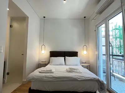 a bedroom with a large bed with two towels on it at Elegant Two Bedroom Apartment a few steps from Plaka in Athens