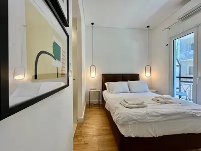 a bedroom with two beds and a large window at Elegant Two Bedroom Apartment a few steps from Plaka in Athens