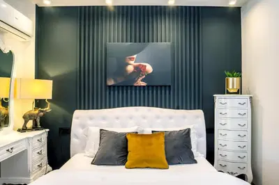 a bedroom with a white bed and a black wall at EcoStay - Infinity business class 2BDR apartment by the sea in Alimos in Athens