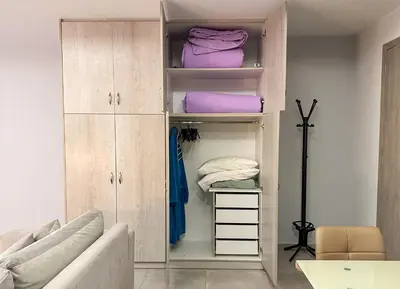 a closet with wooden cabinets and purple towels at Glamorous & Spacious Renovated Apartment, Syntagma, DT Athens in Athens