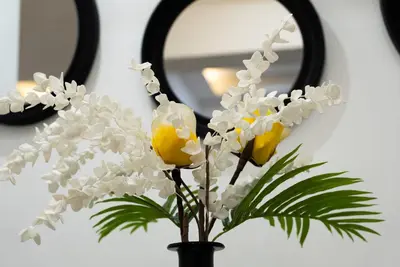 a vase with white flowers in front of a mirror at Romeo & Juliet In the heart of Athens in Athens