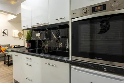 a kitchen with white cabinets and a stove top oven at Romeo & Juliet In the heart of Athens in Athens