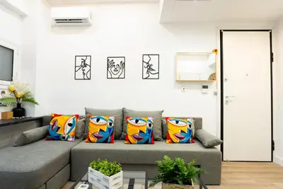 a living room with a gray couch with colorful pillows at Romeo & Juliet In the heart of Athens in Athens