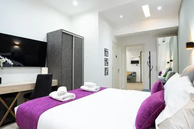 a bedroom with a large bed with a purple blanket at Romeo & Juliet In the heart of Athens in Athens