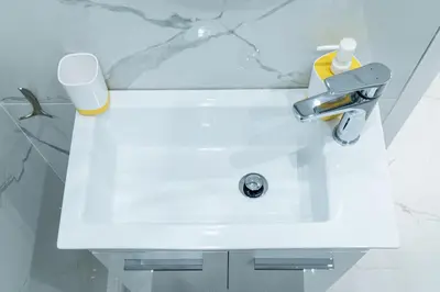 a white sink in a white bathroom with aaucet at King Davids Suite Athens finest! in Athens