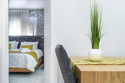 a bedroom with a bed and a table with a potted plant at King Davids Suite Athens finest! in Athens