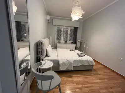 a bedroom with a bed and a chair and a mirror at Acropolis Casa 2bdr/2bthr w/hot tub-3mins to plaka in Athens