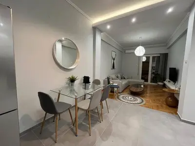 a dining room with a table and chairs and a living room at Acropolis Casa 2bdr/2bthr w/hot tub-3mins to plaka in Athens