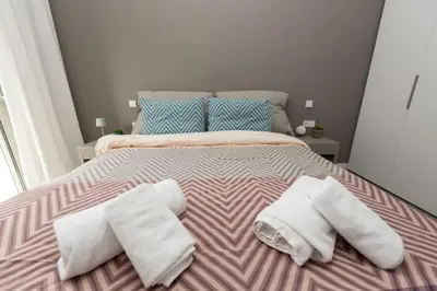 a bed with two white towels on top of it at Brand-new flat with a city view (FORM_G1) in Athens