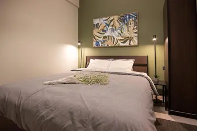 a bedroom with a bed with a painting on the wall at 15 minutes from Acropolis apartment in Athens