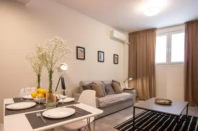 a living room with a table and a couch at 15 minutes from Acropolis apartment in Athens