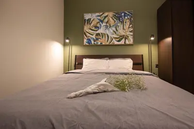 a bedroom with a bed with a pillow and a painting at 15 minutes from Acropolis apartment in Athens