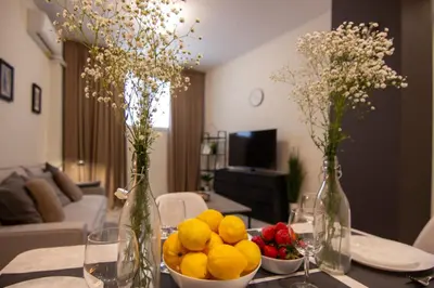 a table with a bowl of fruit and two vases at 15 minutes from Acropolis apartment in Athens