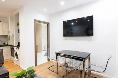 a living room with a table and a television on a wall at Paradise Syntagma Family Apartment in Athens