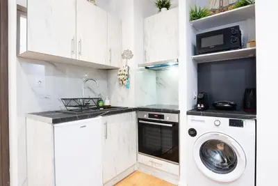 a kitchen with white cabinets and a washer and dryer at Paradise Syntagma Family Apartment in Athens