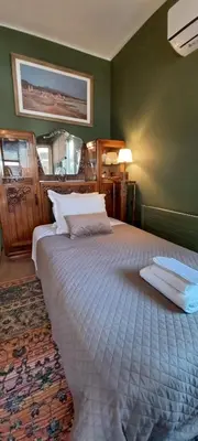 a bedroom with a large bed in a green wall at 115m2 K.G HOME in Athens