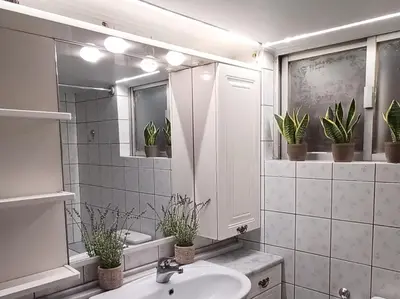 a bathroom with a sink and a mirror and potted plants at 115m2 K.G HOME in Athens