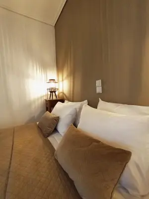 a bedroom with a bed with white sheets and pillows at 115m2 K.G HOME in Athens