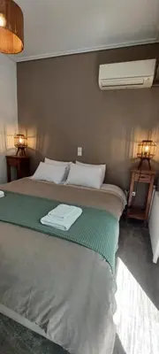 a bedroom with a bed with a green blanket at 115m2 K.G HOME in Athens