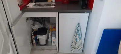 a small white refrigerator under a kitchen counter at Taratsaki in Athens
