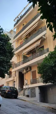 an apartment building with a car parked in front of it at Taratsaki in Athens