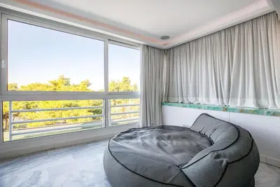 a room with a bean bag chair in front of windows at South Blue Luxury Apartment in Vouliagmeni in Athens