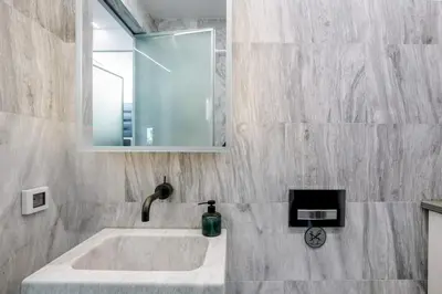 a bathroom with a sink and a mirror at South Blue Luxury Apartment in Vouliagmeni in Athens